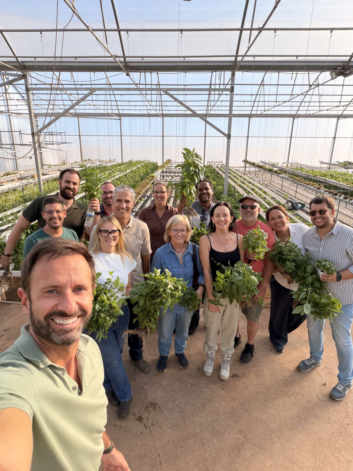 Selfie do Estêvão Anacleto com um grupo de formandos com aromáticas acabadas de colher numa estufa hidropónica